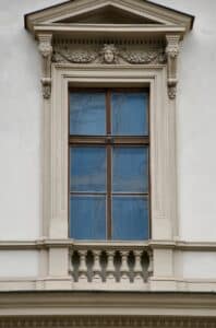 A white building with a window and a clock