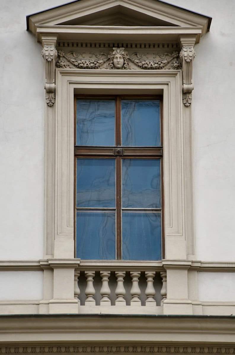 A white building with a window and a clock